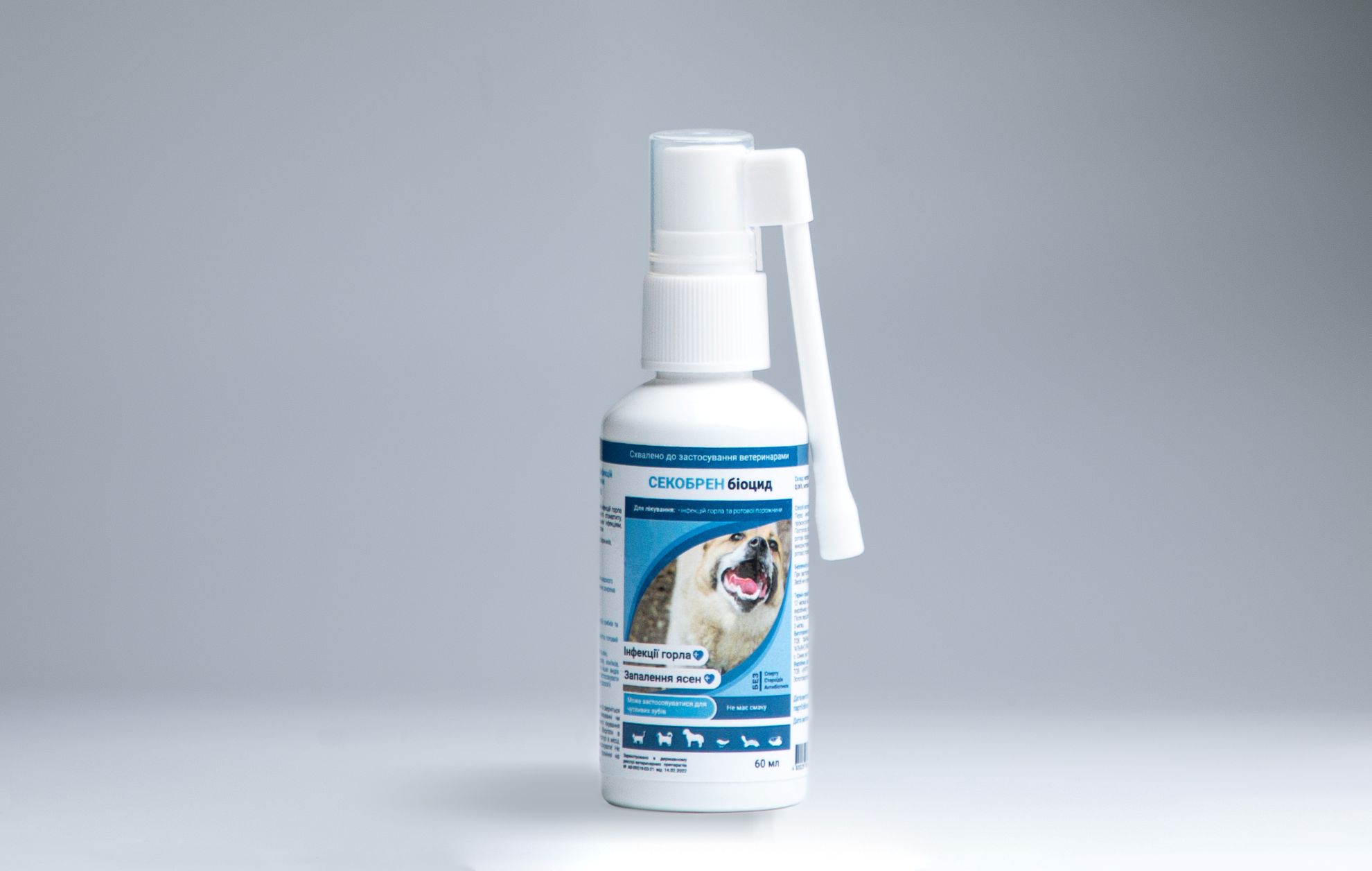 A 60ml bottle of Biocide SECOBREN, an oral and throat infection spray for pets, featuring a long applicator nozzle for targeted treatment and a dog on the label.